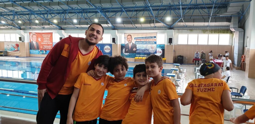Umut’un Galatasaray 2011 yüzme takımı ve antrenörü Eray Hoca ile havuz başında çekilen takım fotoğrafı